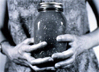 Black and white photo of hands holding jar of canned food.