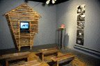 Color photo of an installation of a barn setting with a television showing a video